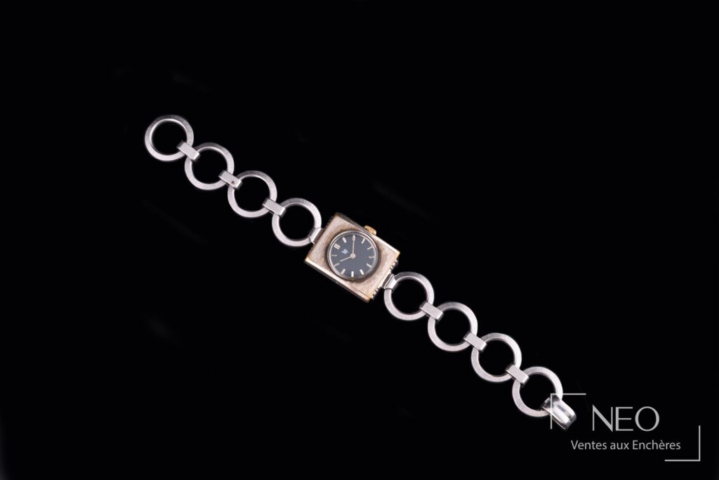 Montre bracelet LIP en acier avec cadran noir et bracelet à anneaux sur fond noir