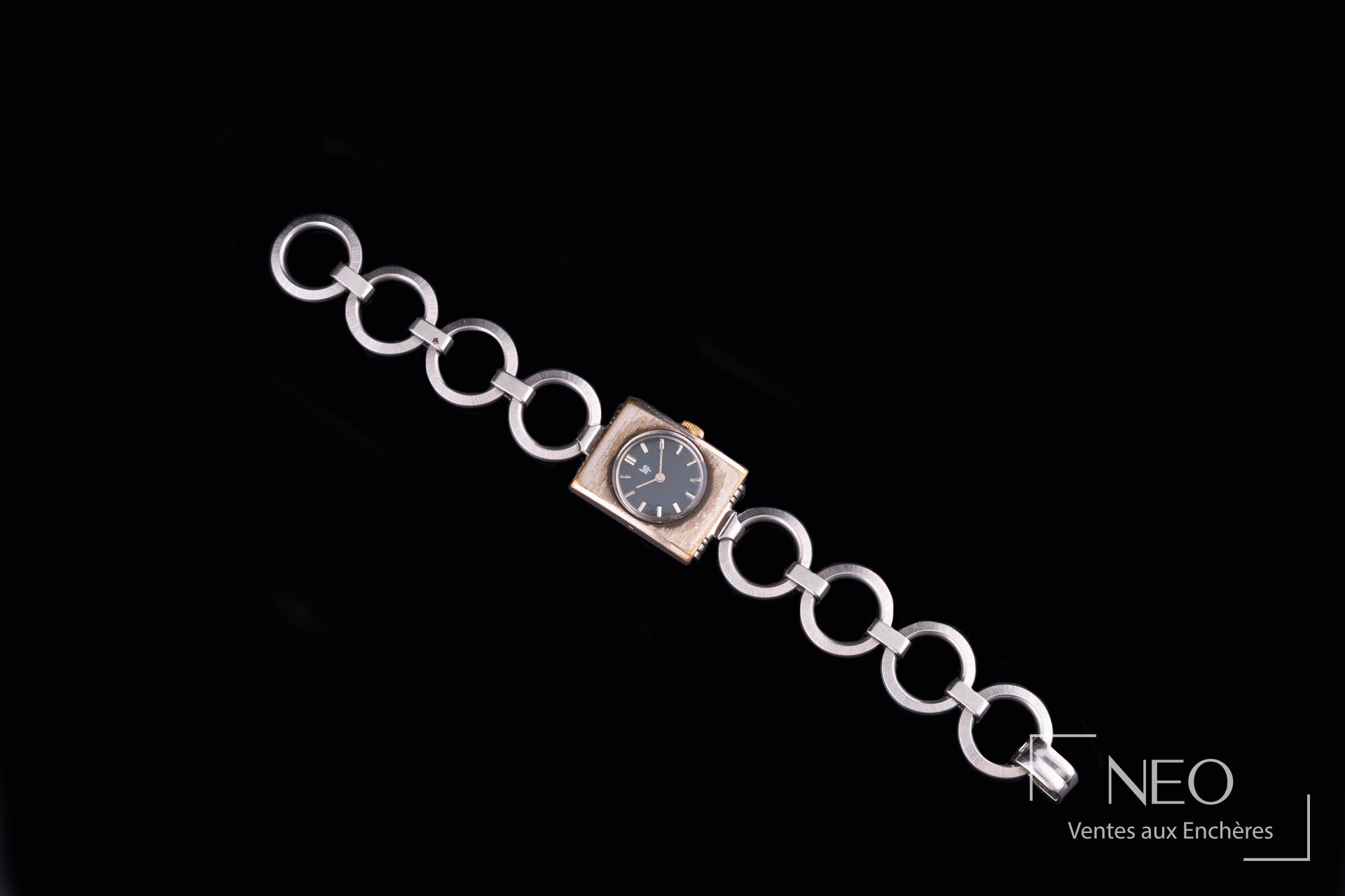 Montre bracelet LIP en acier avec cadran noir et bracelet à anneaux sur fond noir