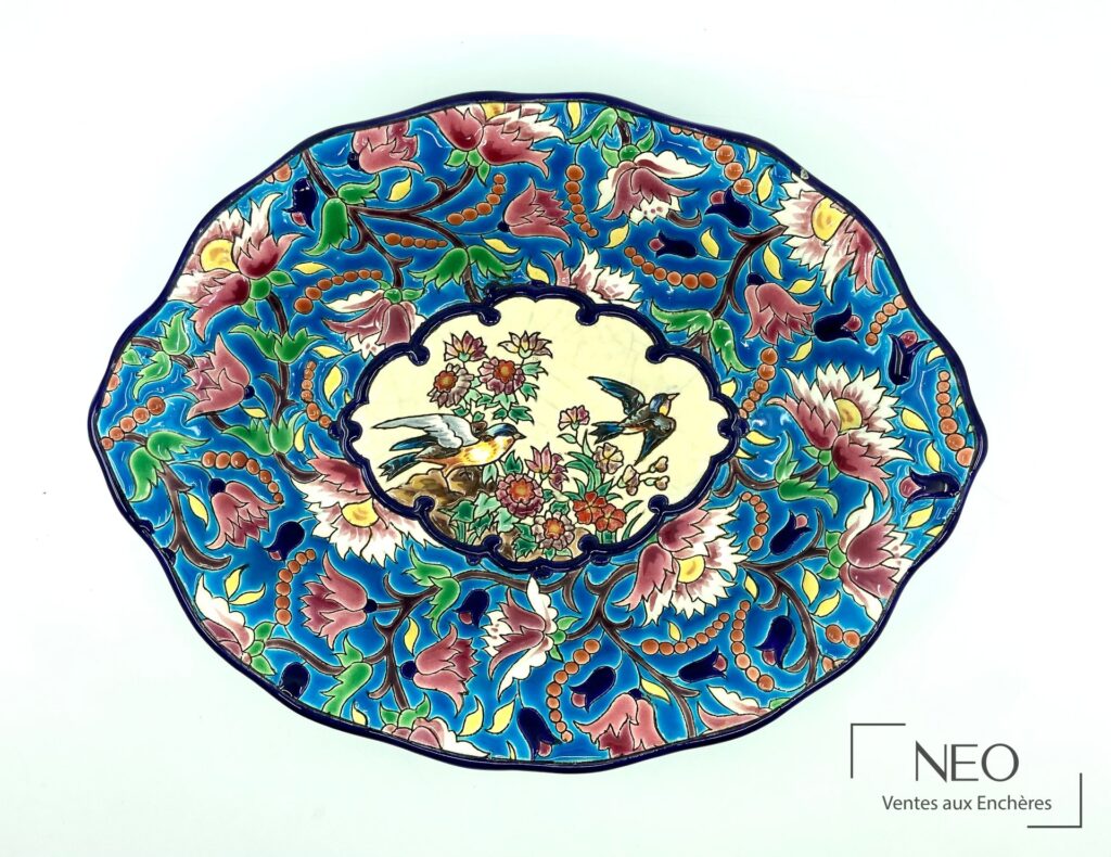 Plat oblong Longwy en émaux polychromes à décor floral et deux oiseaux au centre