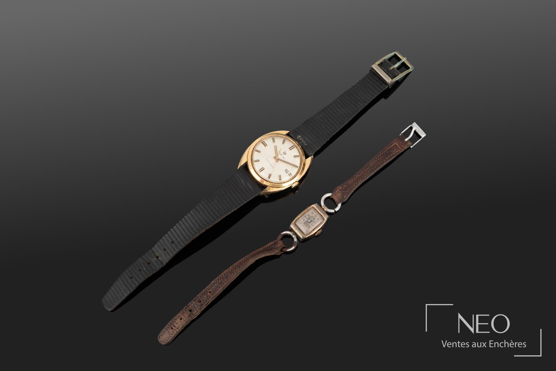 Deux montres bracelets posées en diagonale sur fond sombre