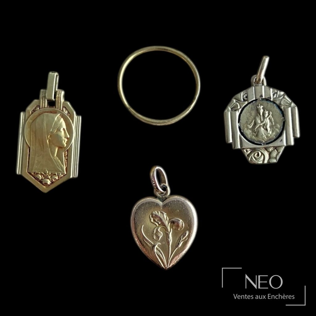 Quatre bijoux et médailles en métal doré