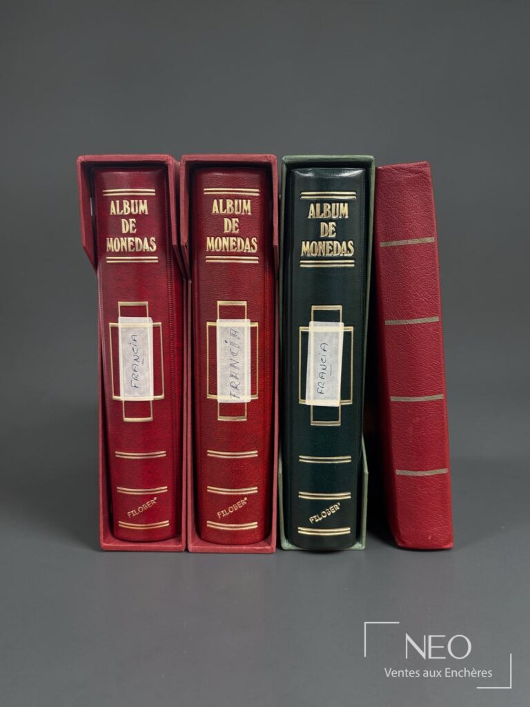 Trois classeurs de monnaies et un album rouge présentés de face