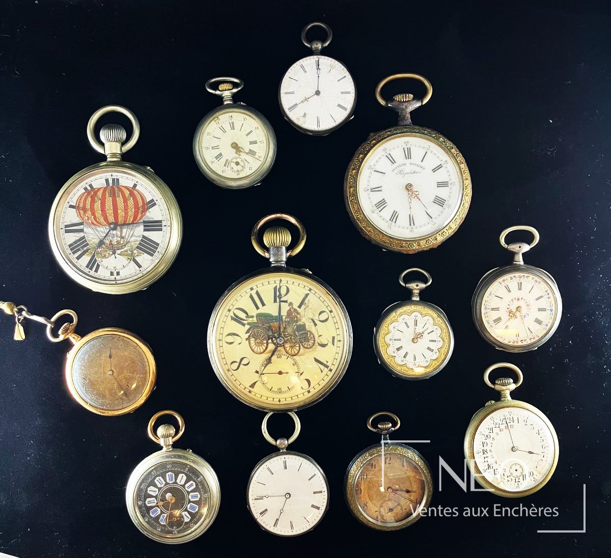 Lot de montres de gousset et régulateurs anciens disposés sur fond noir