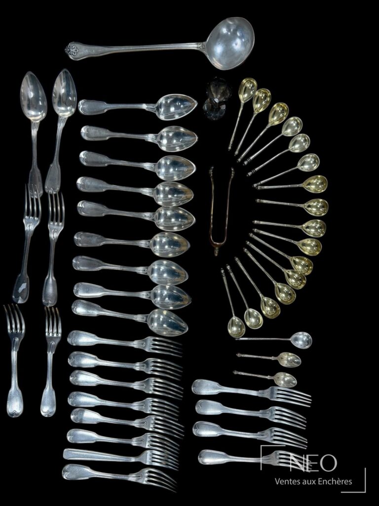 Ensemble de couverts et pièces de service en argent et vermeil sur fond noir