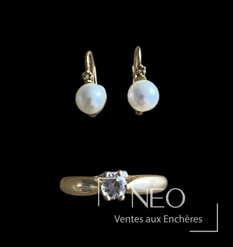 Solitaire en or jaune avec diamant et paire de boucles d'oreille à perles sur fond noir