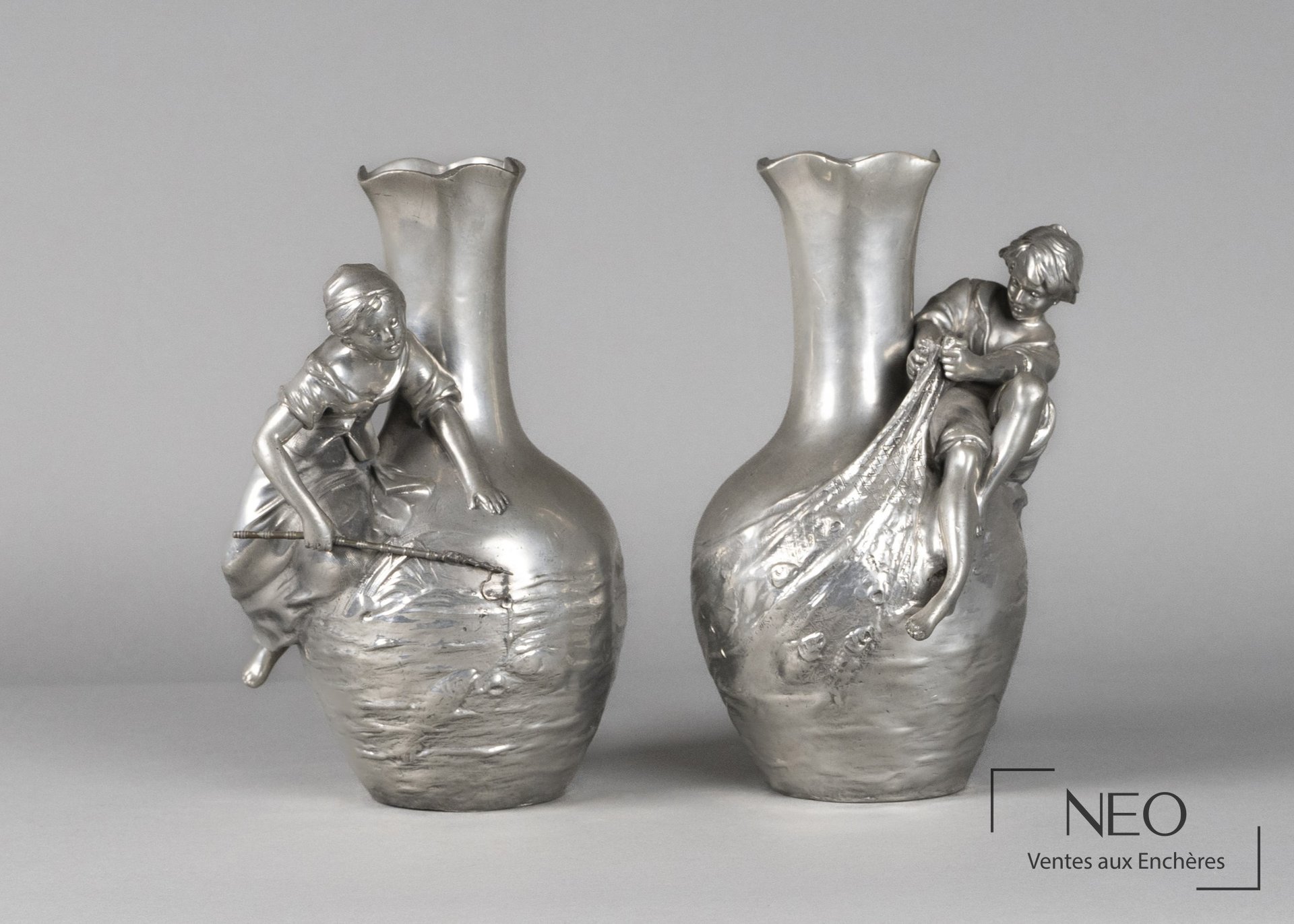 Paire de vases en étain à décor d'enfants pêcheurs en haut-relief