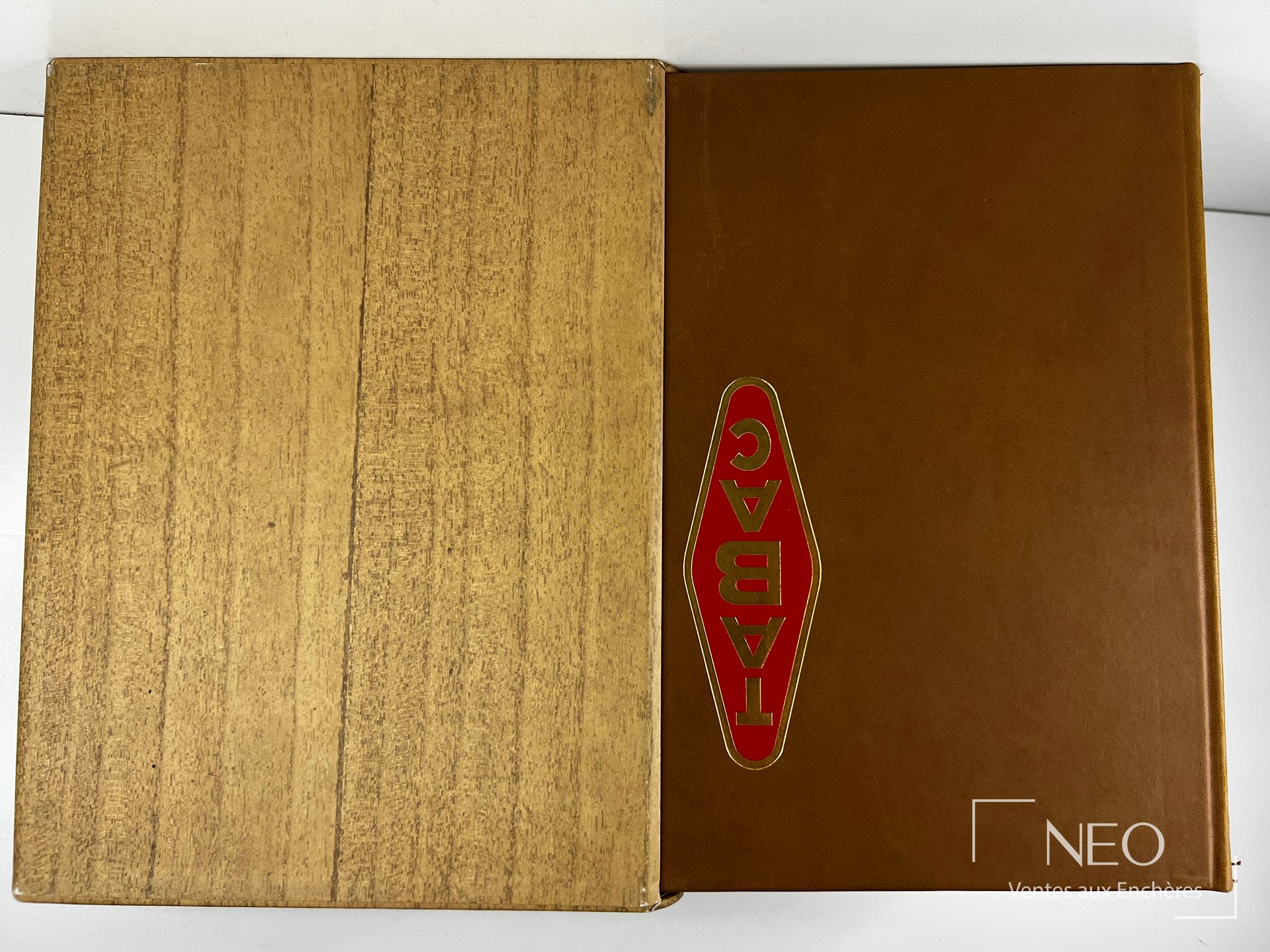 Livre sous coffret imitation bois et reliure éditeur pleine cuir havane