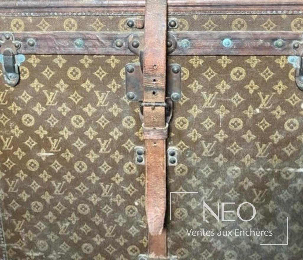 Face d'une malle Louis Vuitton en toile monogram avec sangle centrale en cuir et serrures en laiton