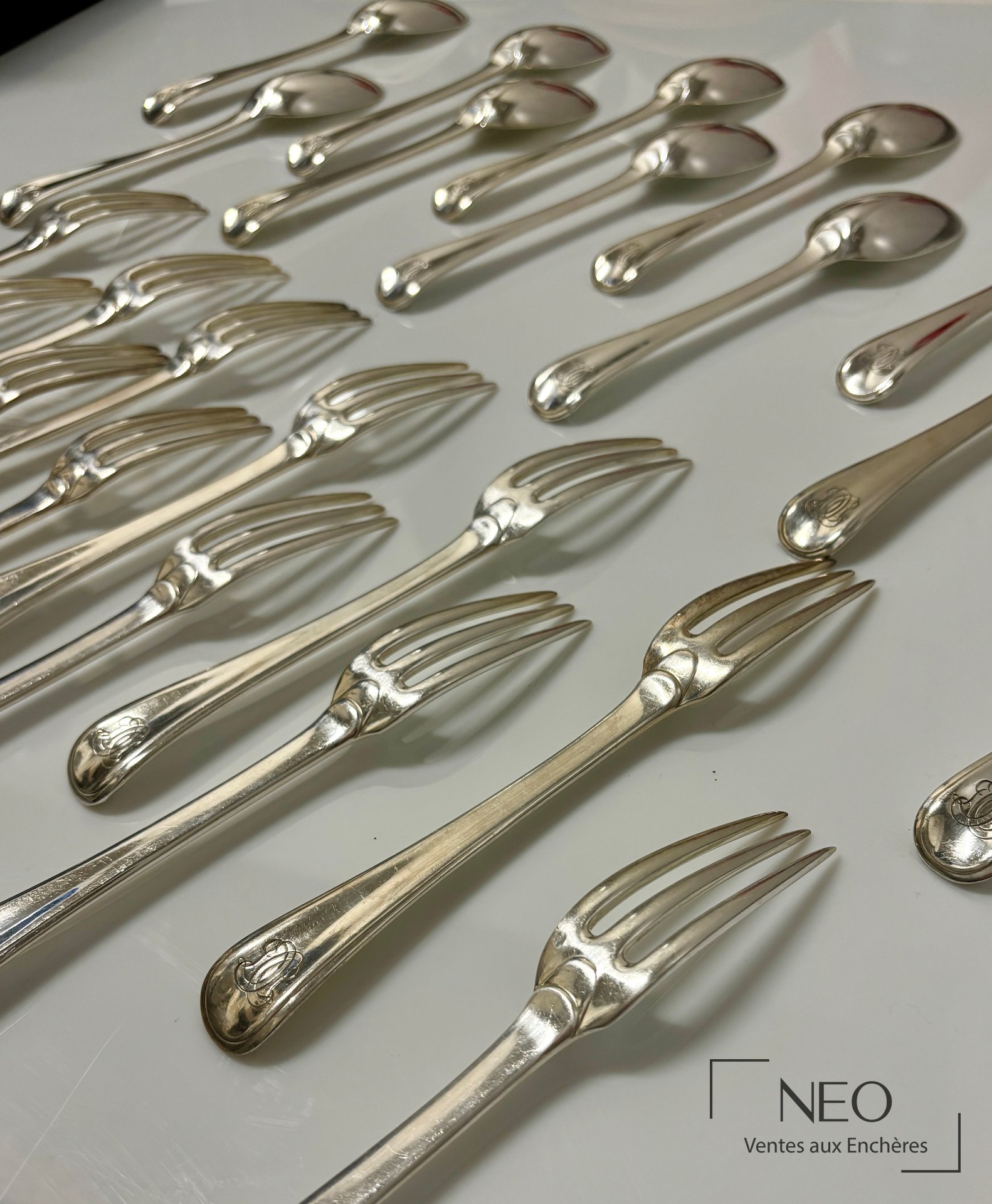 Ensemble de cuillères et de fourchettes en argent présenté sur fond clair