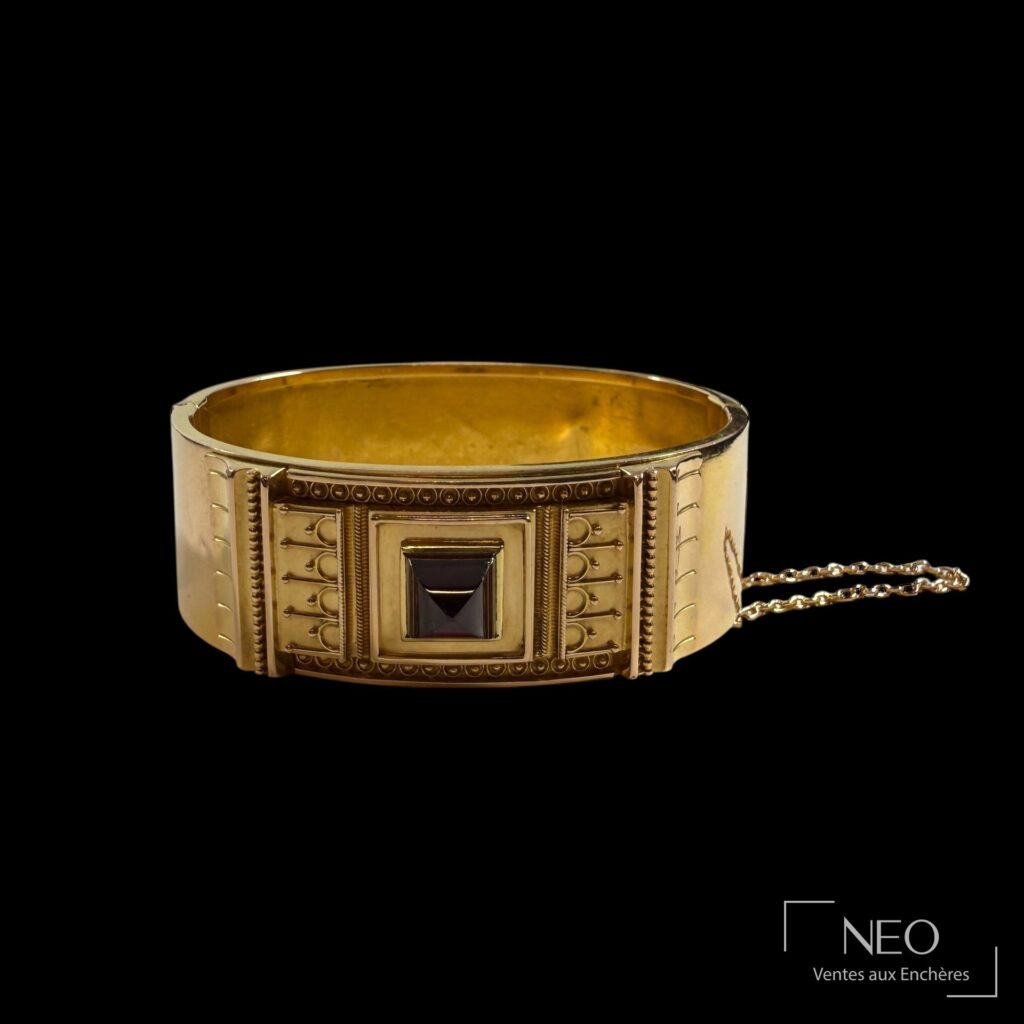 Bracelet jonc ouvrant en or jaune avec décor orientaliste et grenat central