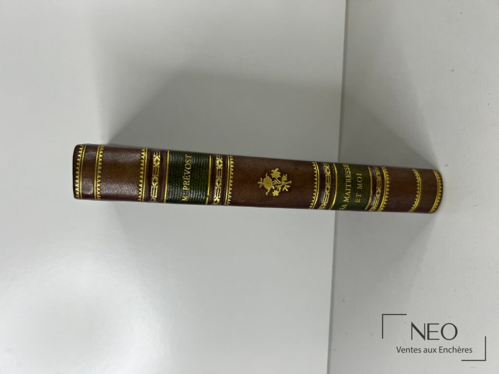 Dos d'un livre relié en demi basane avec titre doré et caissons ornés.