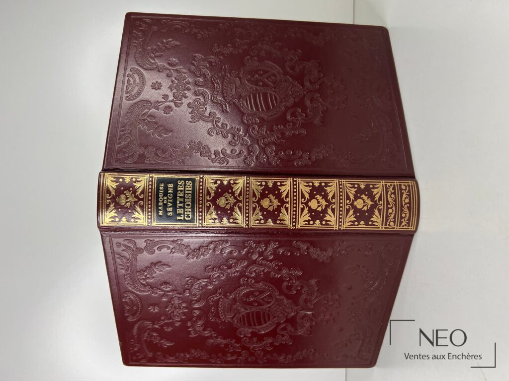 Livre relié bordeaux avec dos doré et motifs décoratifs