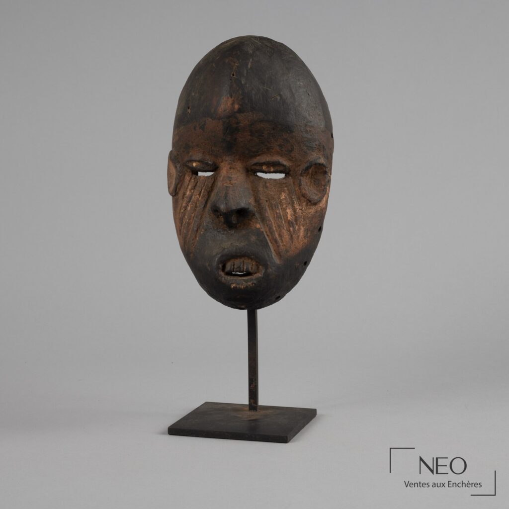 Masque Ibibio en bois vu de face sur son support métallique