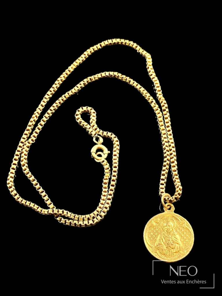 Médaille en or jaune avec chaîne vénitienne sur fond noir