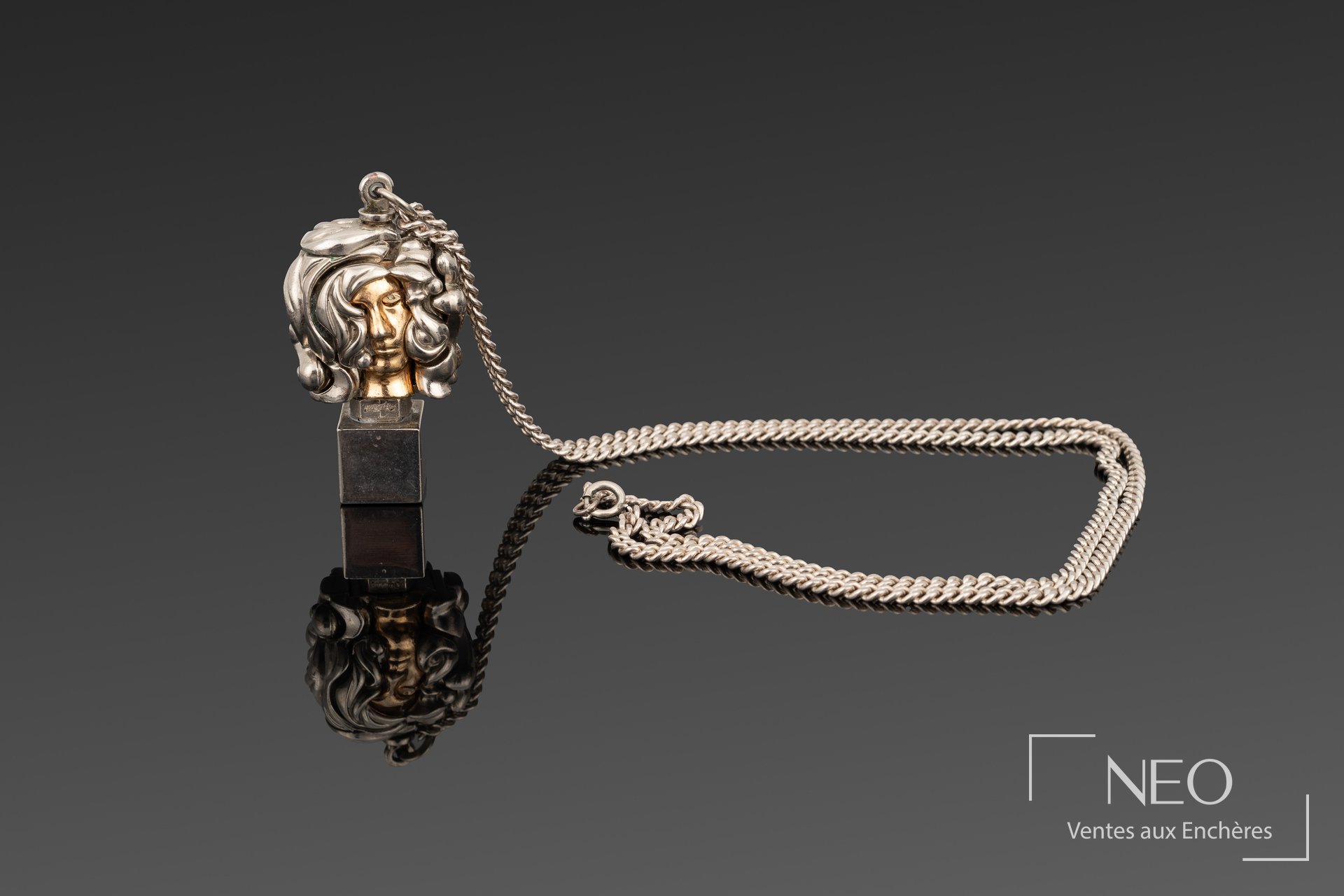 Chaîne de cou avec pendentif sculptural articulé figurant un visage féminin et chaîne torsadée