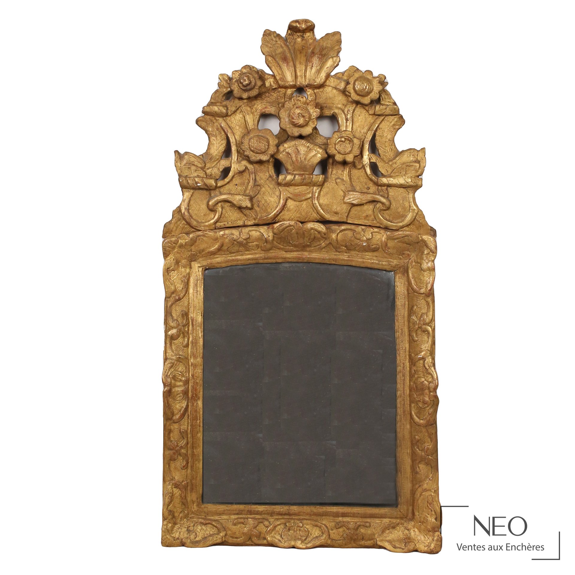Miroir en bois sculpté et doré à fronton fleuri
