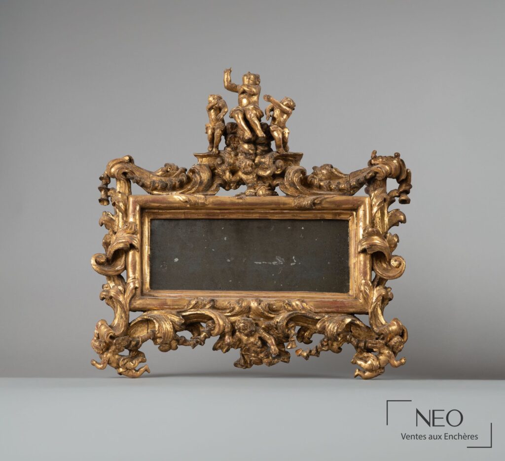 Miroir italien doré à fronton sculpté de putti