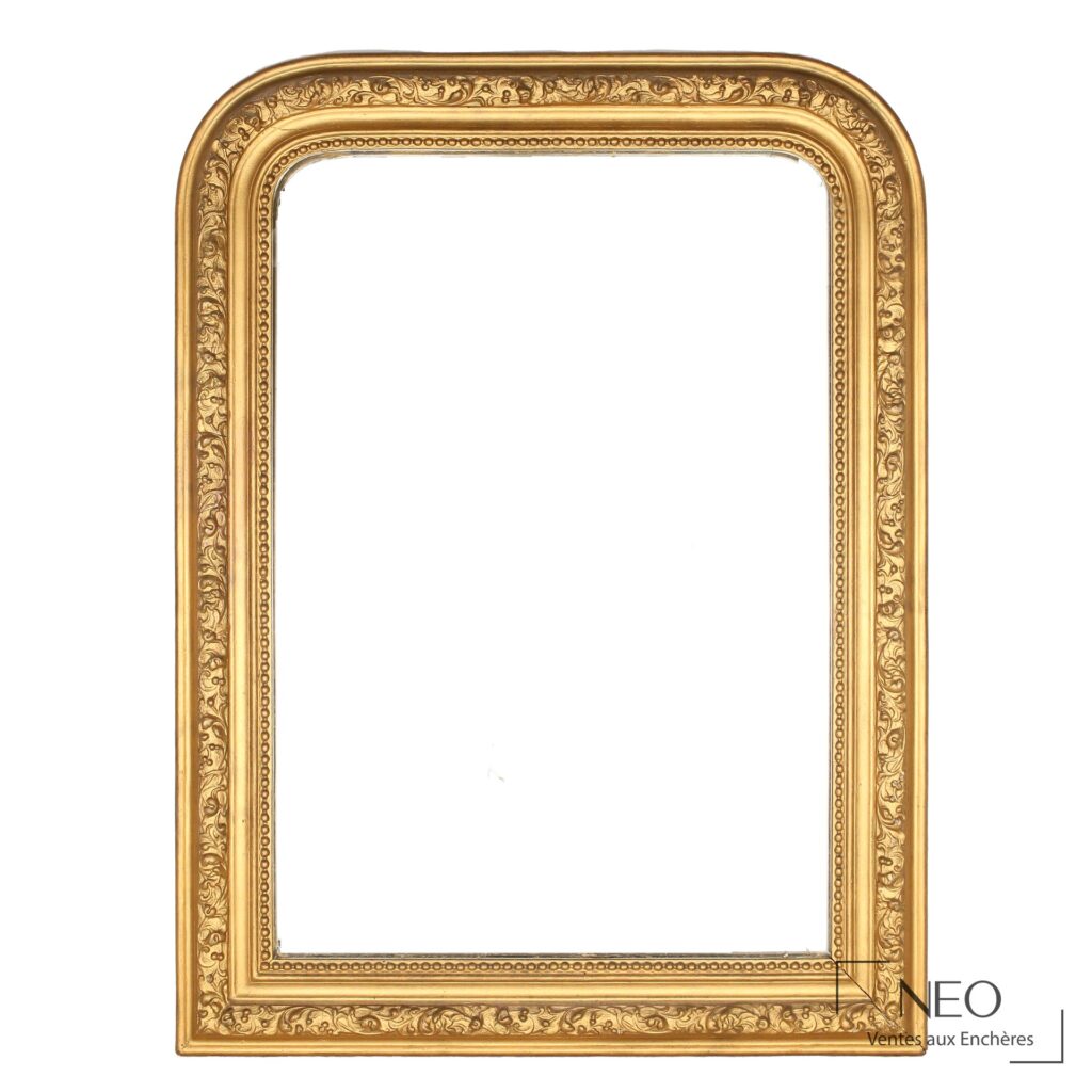 Miroir rectangulaire en bois sculpté et doré à décor de perles et feuillages