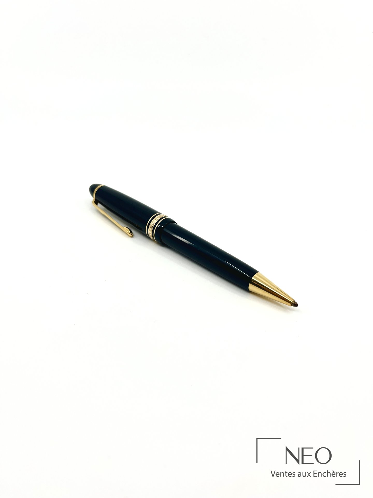 Stylo bille Montblanc Meisterstück en résine noire et métal doré sur fond blanc