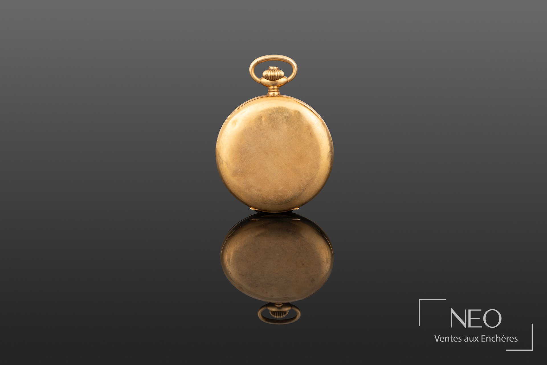 Dos d'une montre à gousset en or jaune avec bélière et boîtier rond