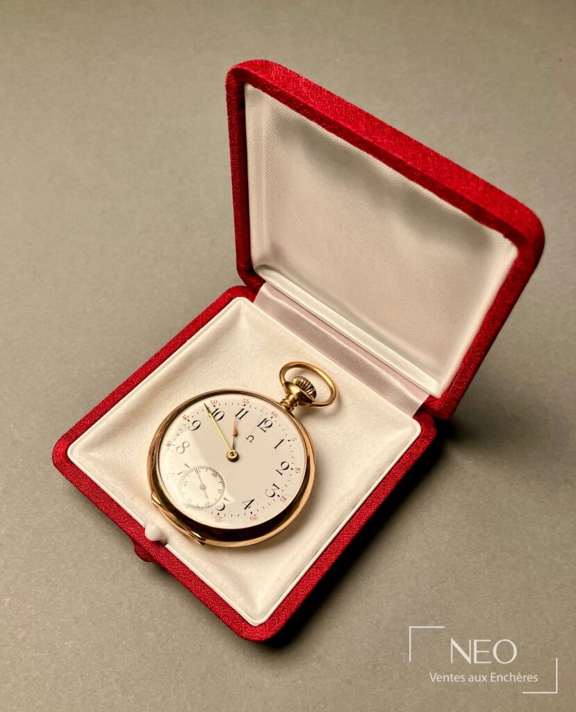 Montre à gousset en or jaune avec cadran émaillé blanc présentée dans un écrin rouge