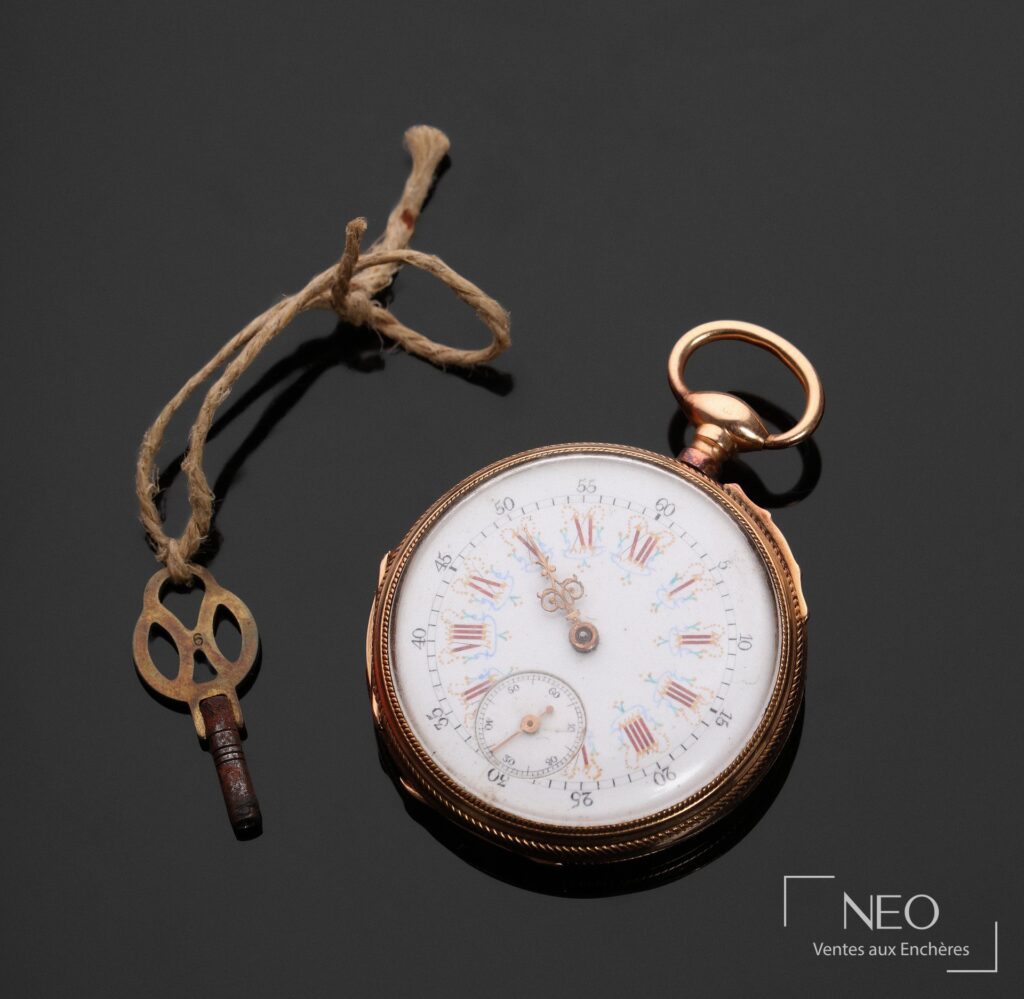 Montre à gousset en or rose avec cadran émaillé blanc et clé sur fond sombre