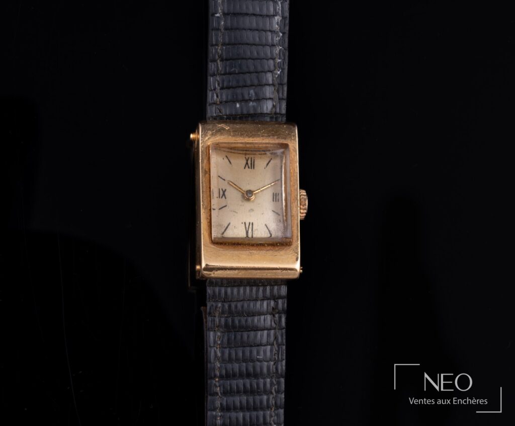 Montre bracelet rectangulaire en or jaune sur bracelet noir