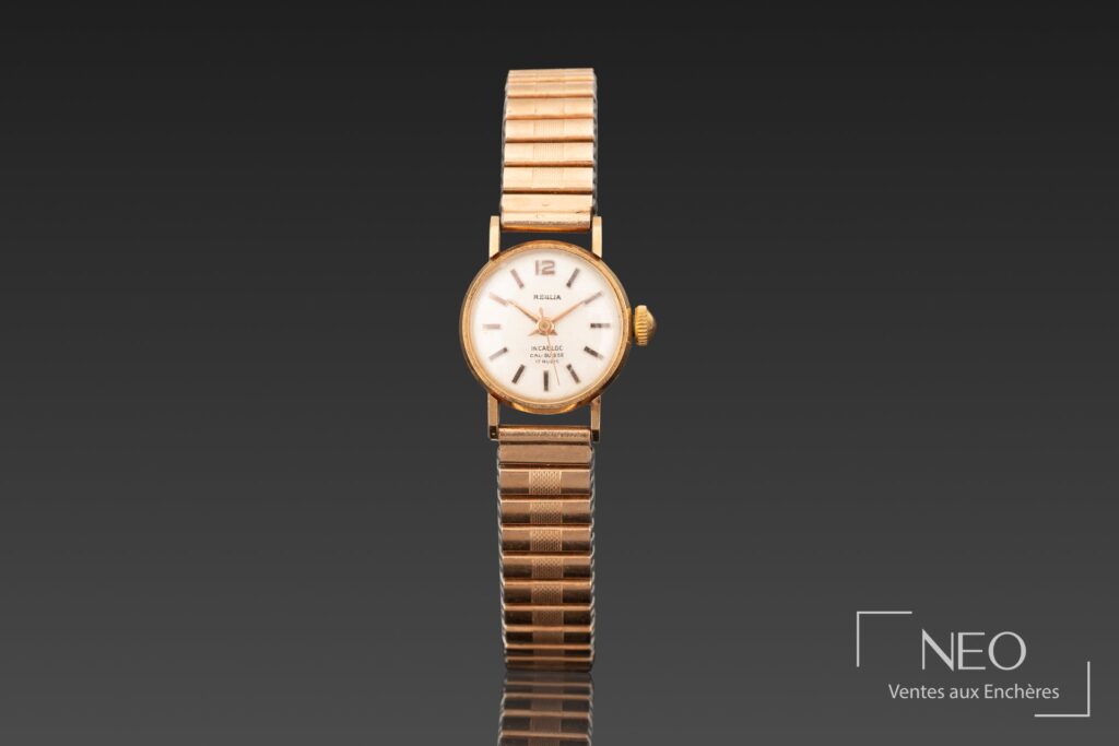 Montre bracelet REGLIA en or jaune avec cadran clair et bracelet Fixoflex.