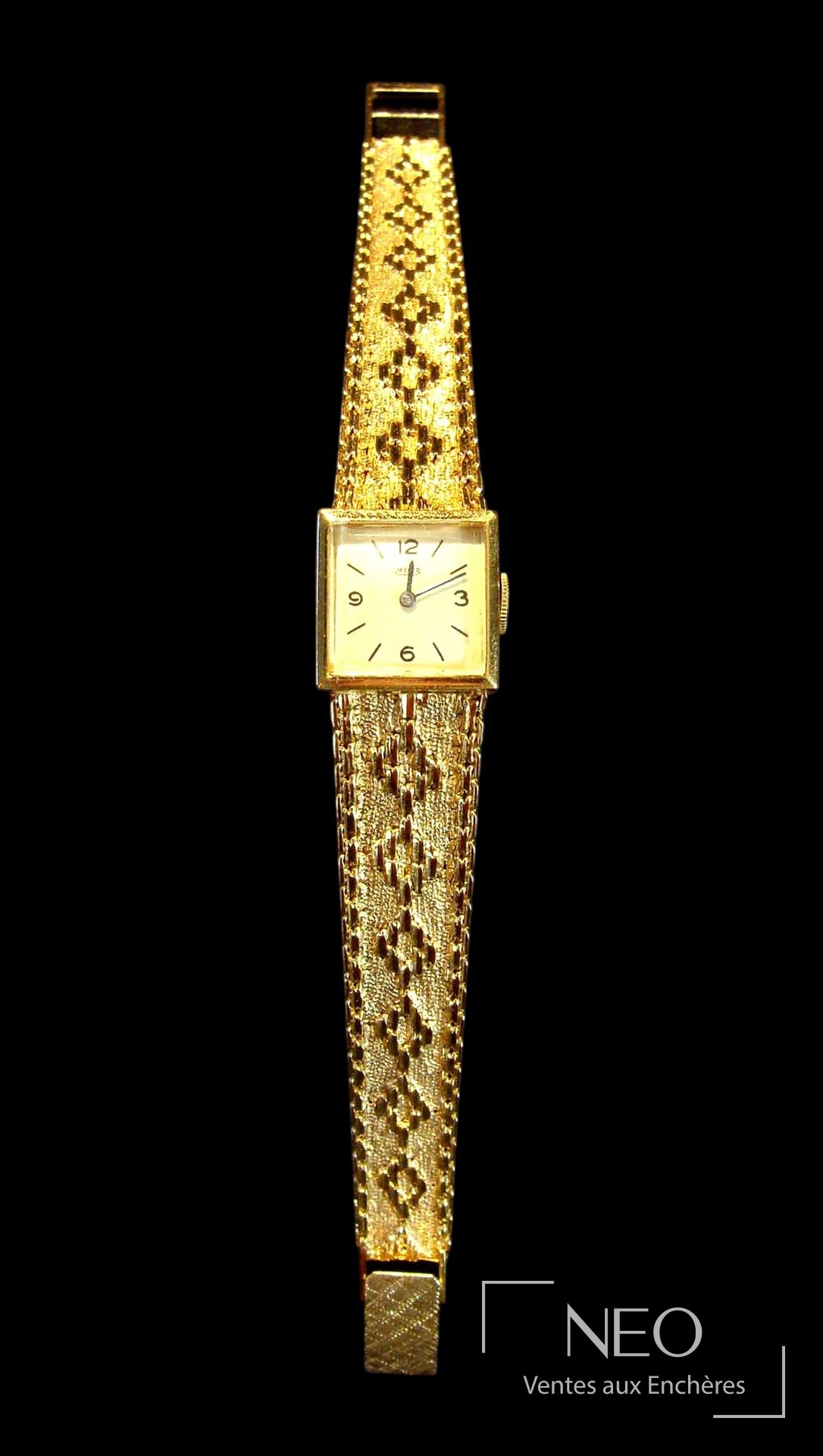 Montre Jaeger en or jaune avec boîtier carré et bracelet ajouré sur fond noir