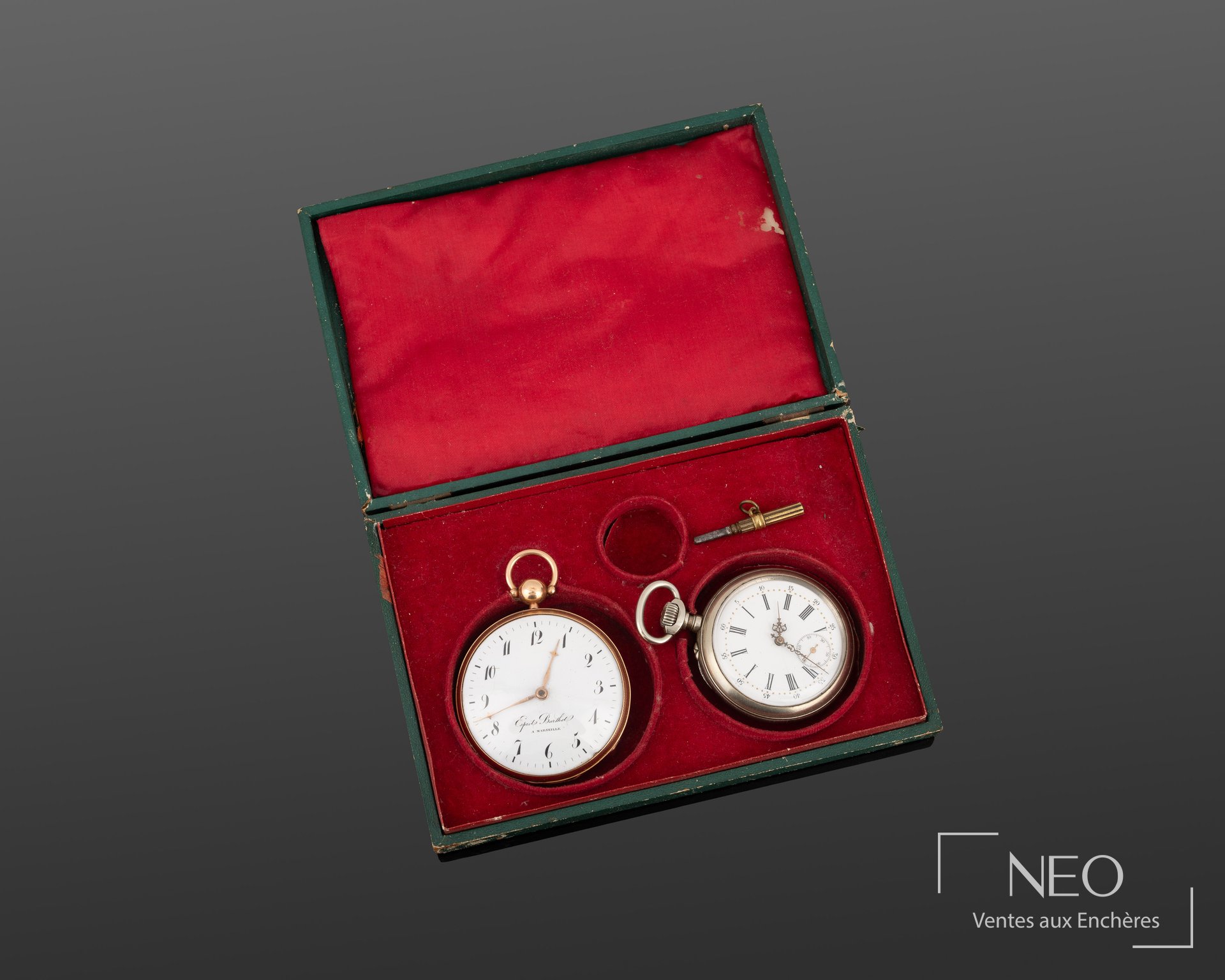 Écrin ouvert contenant deux montres à gousset et leur clef sur velours rouge