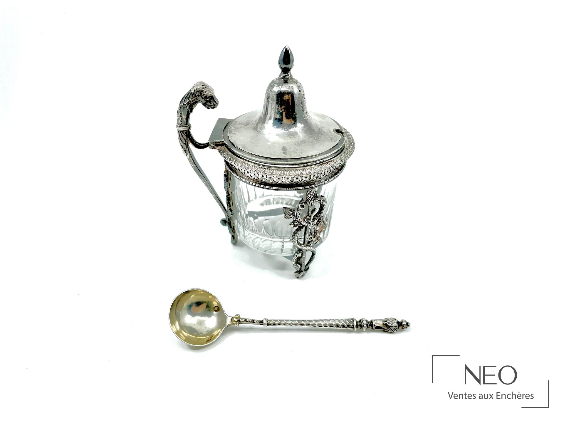 Moutardier en argent avec cuillère à sel présentés ensemble sur fond clair