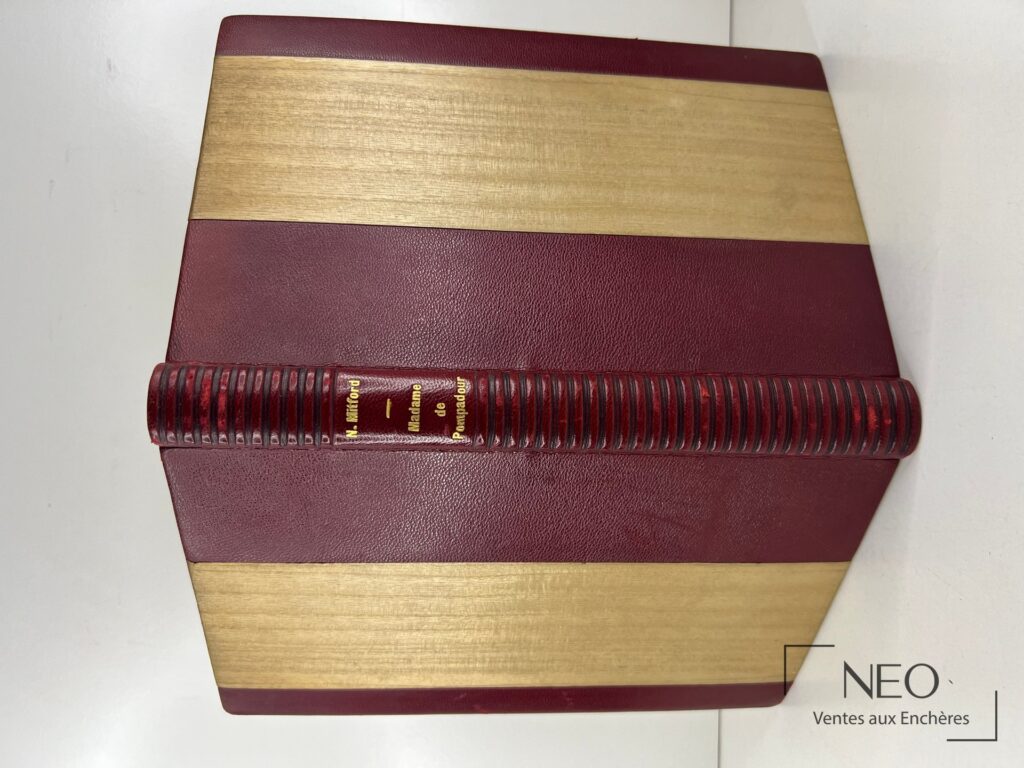 Livre relié en demi chagrin bordeaux avec bandes beiges et titre doré au dos