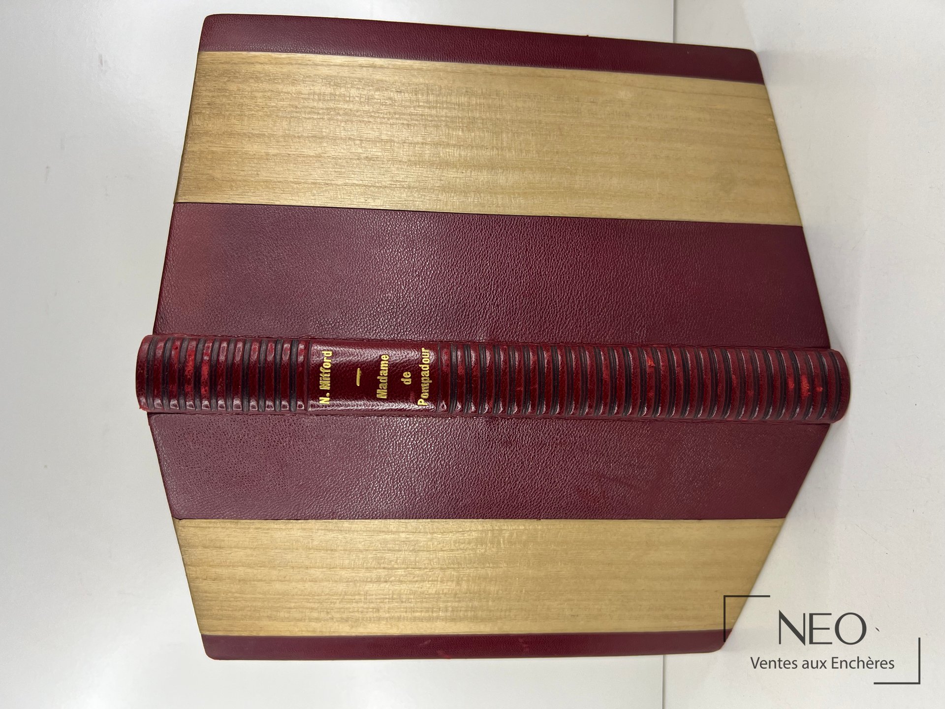 Livre relié en demi chagrin bordeaux avec bandes beiges et titre doré au dos