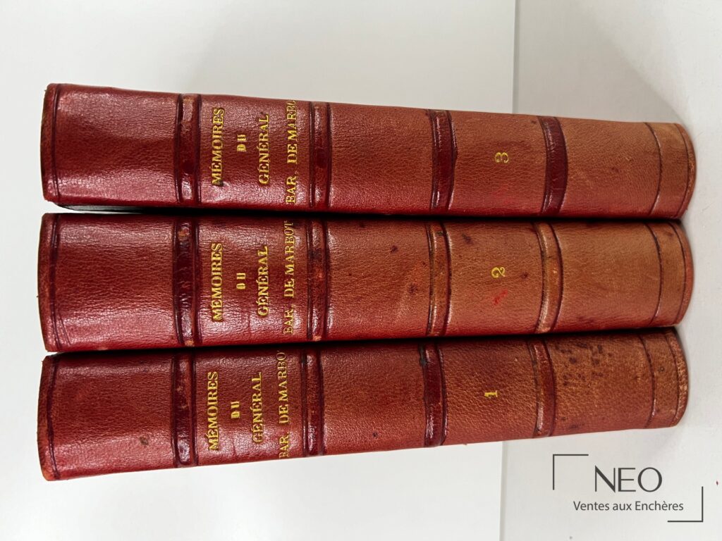 Trois dos de volumes reliés en basane rouge avec titres dorés et numéros 1