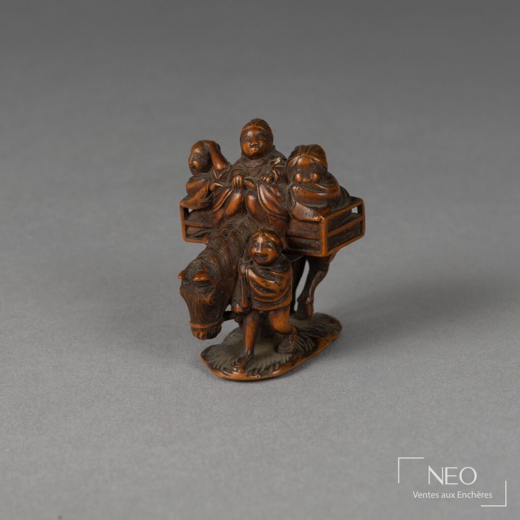 Netsuke en buis représentant trois personnages sur un cheval