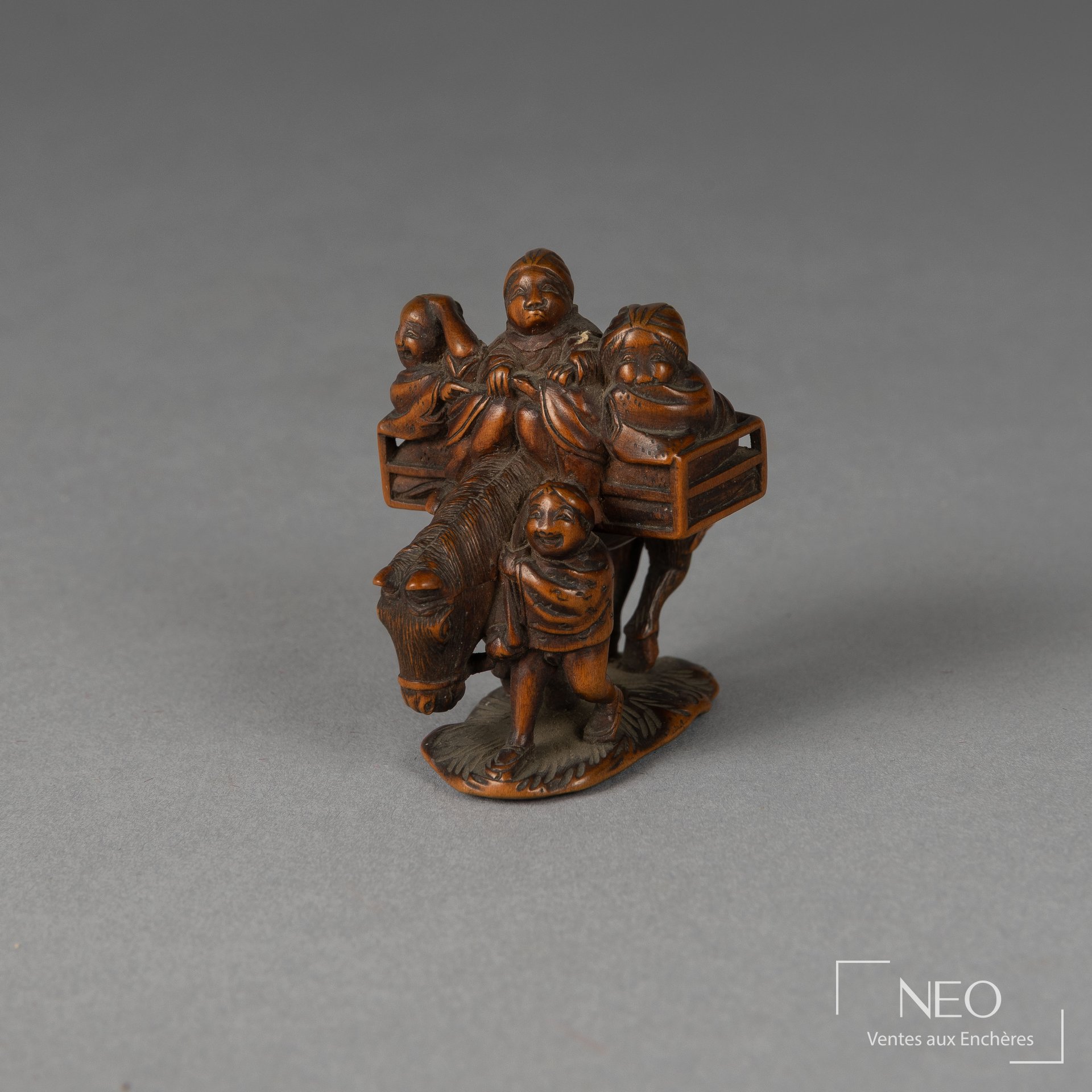 Netsuke en buis représentant trois personnages sur un cheval