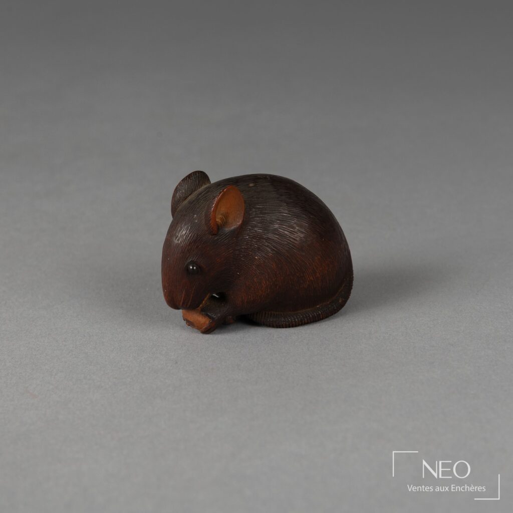 Netsuke en buis représentant un rat assis tenant un fruit