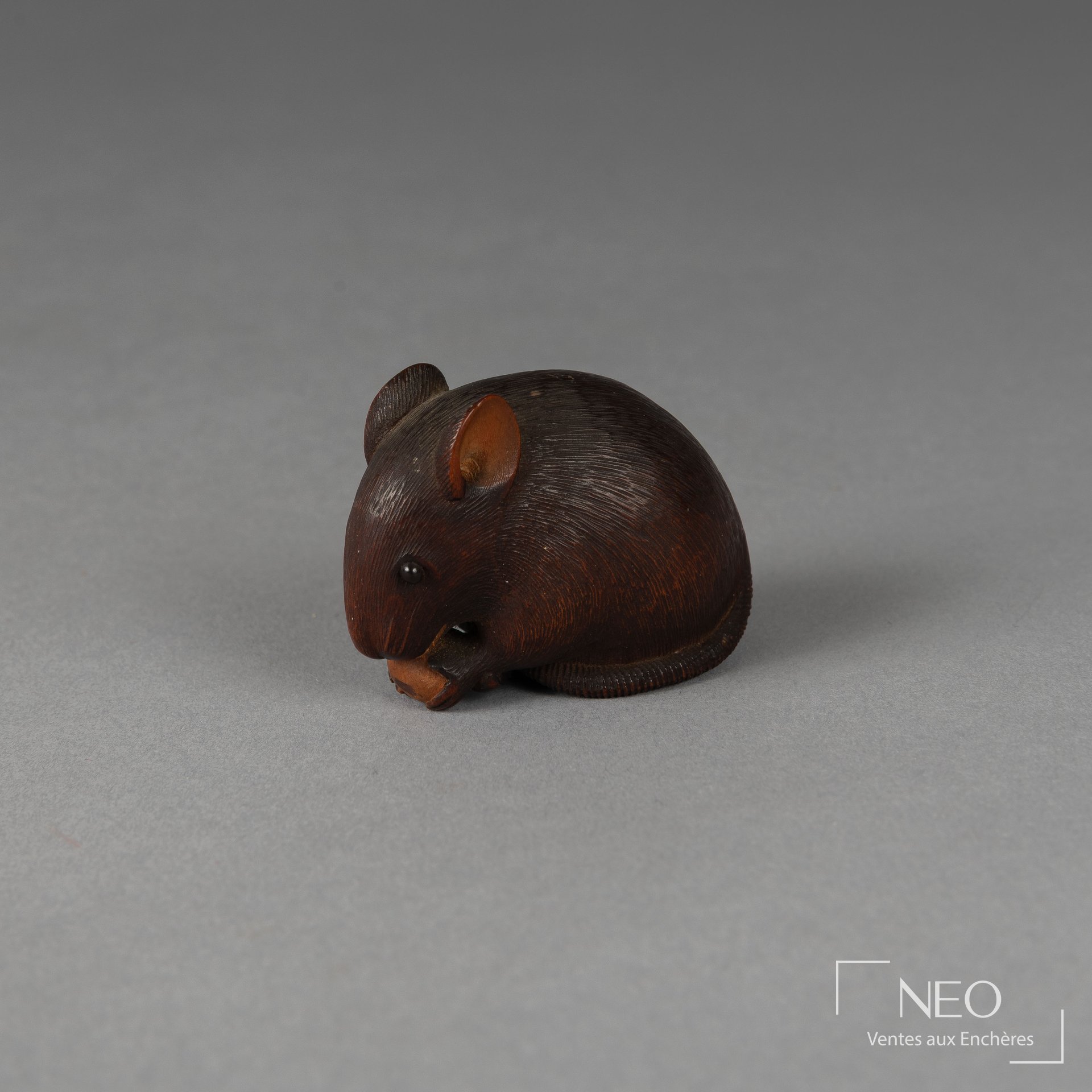 Netsuke en buis représentant un rat assis tenant un fruit
