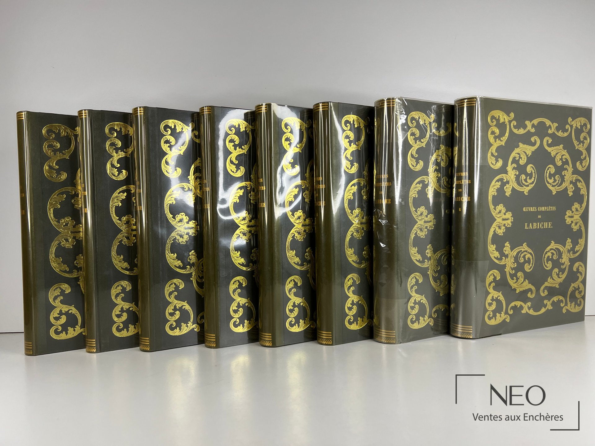 Huit volumes noirs et or des Oeuvres completes de Labiche alignes de face.