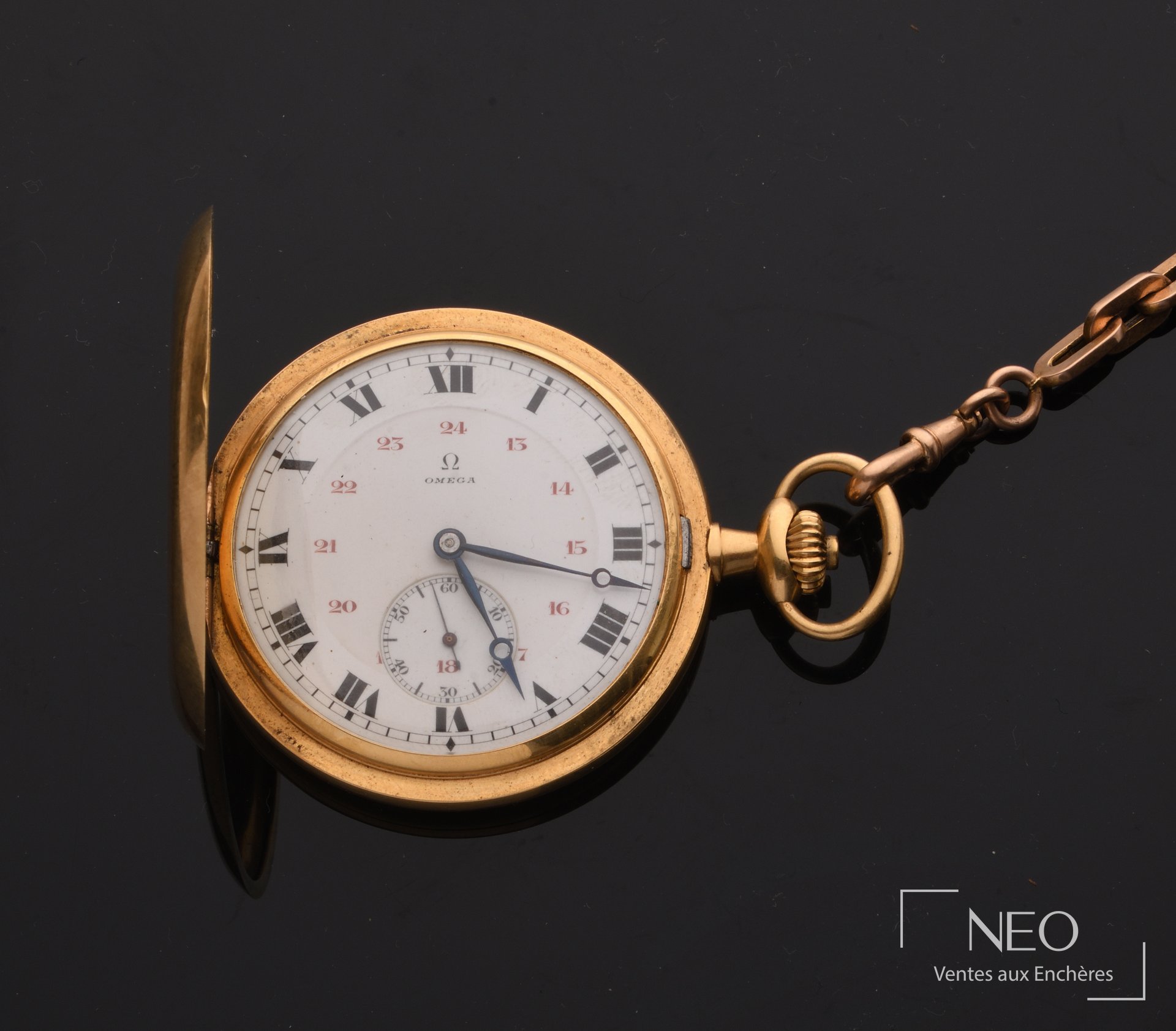 Montre à gousset OMEGA ouverte avec cadran émaillé blanc et chaîne en or rose.