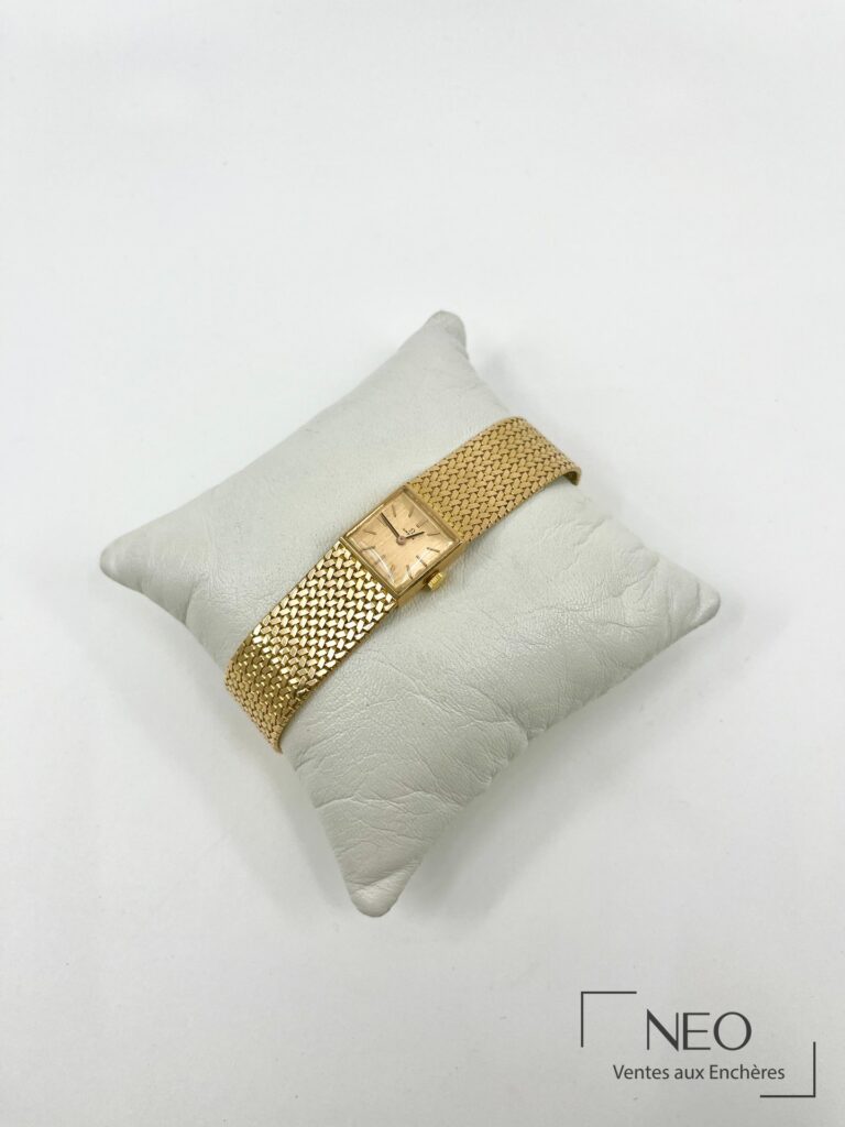 Montre Omega de dame en or jaune sur coussin