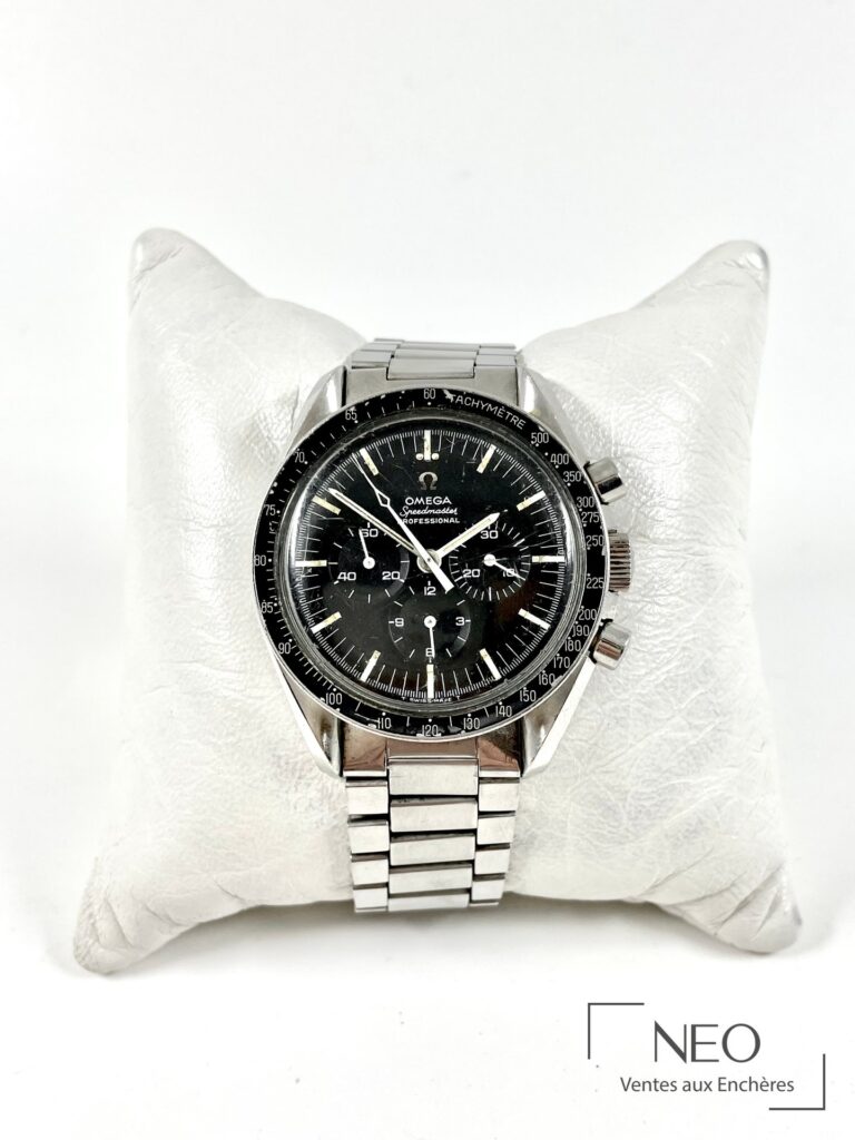 Omega Speedmaster pré moon au cadran noir mat et bracelet acier sur coussin blanc
