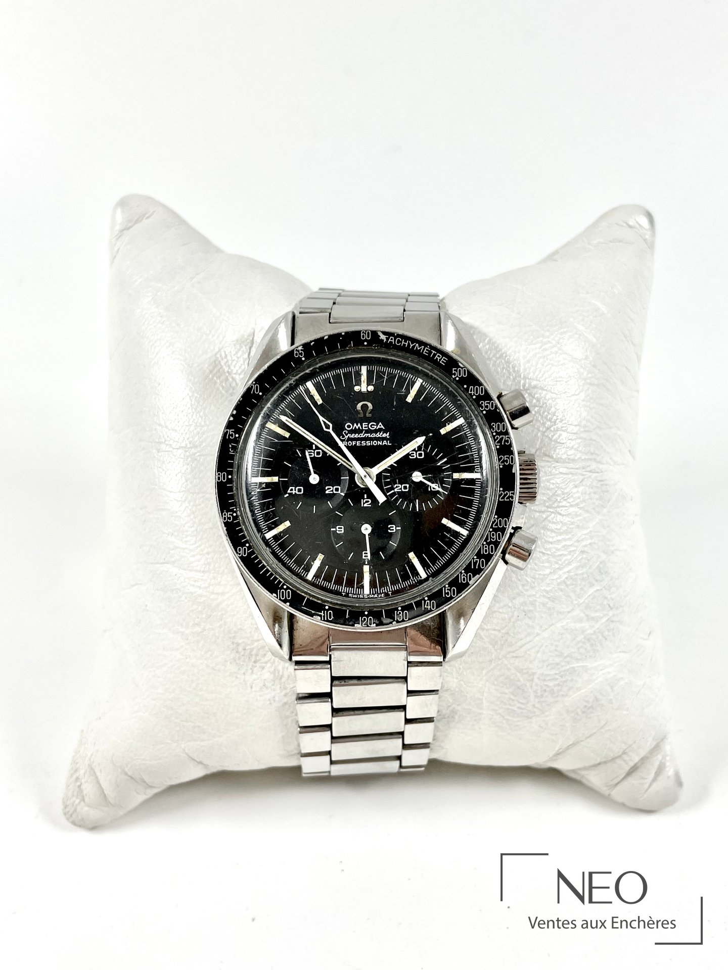 Omega Speedmaster pré moon au cadran noir mat et bracelet acier sur coussin blanc