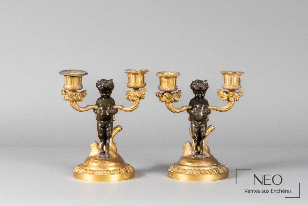 Paire de candélabres en bronze patiné et doré à décor de jeune faune