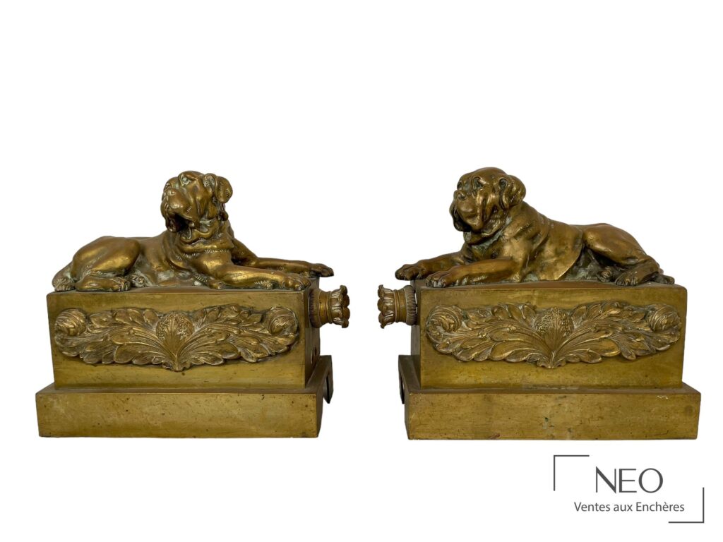 Paire de chenets en bronze doré figurant deux chiens allongés sur base rectangulaire