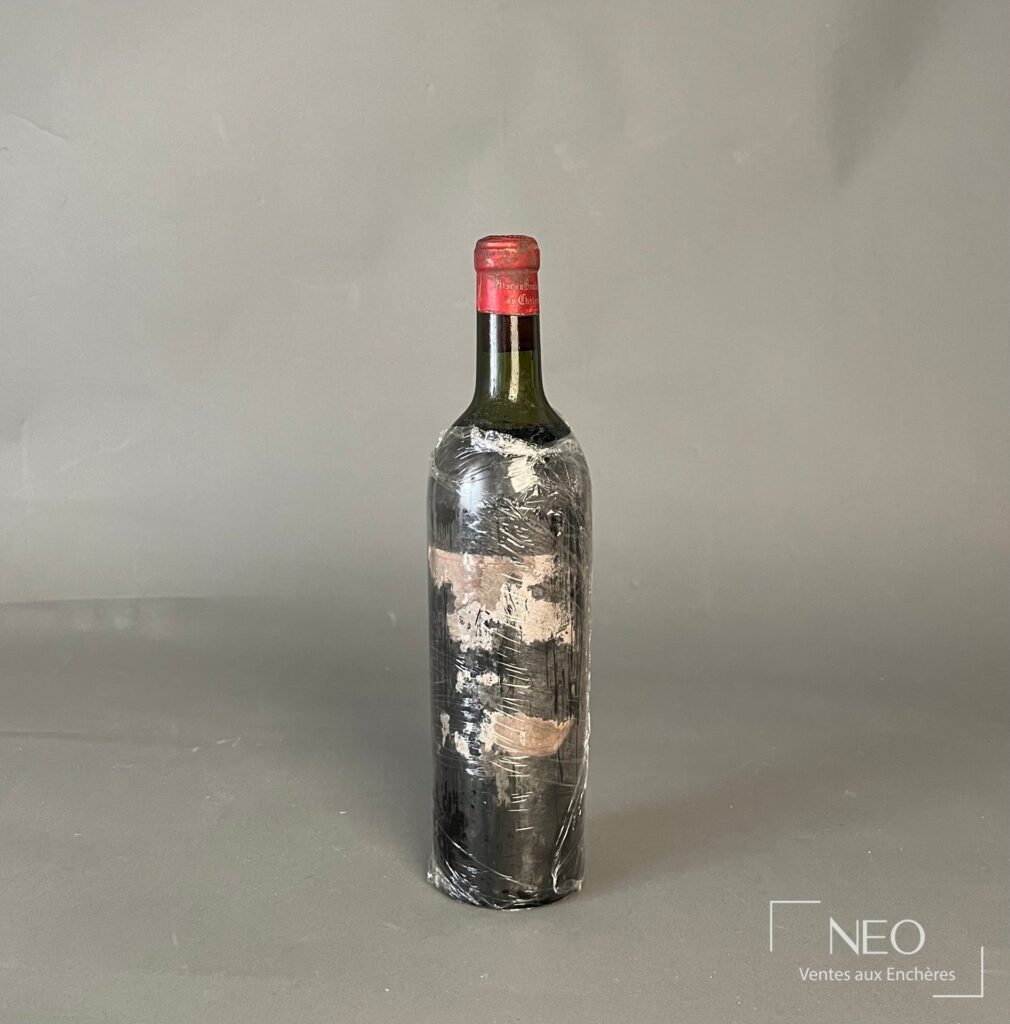 Bouteille de Pauillac Château Lynch Bages présentant une étiquette très dégradée et un bouchon rouge marqué 1945