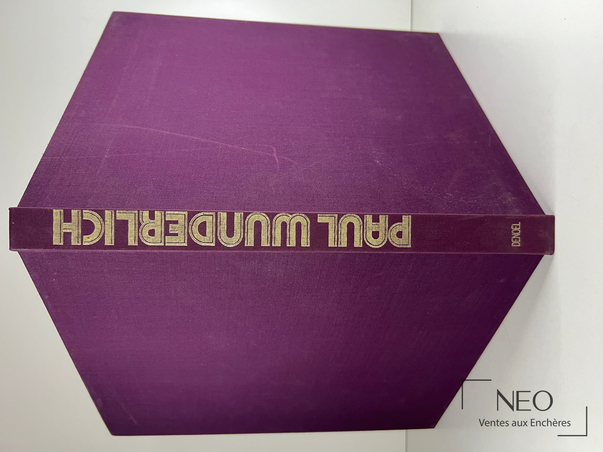 Couverture violette rigide avec titre doré sur le dos du livre