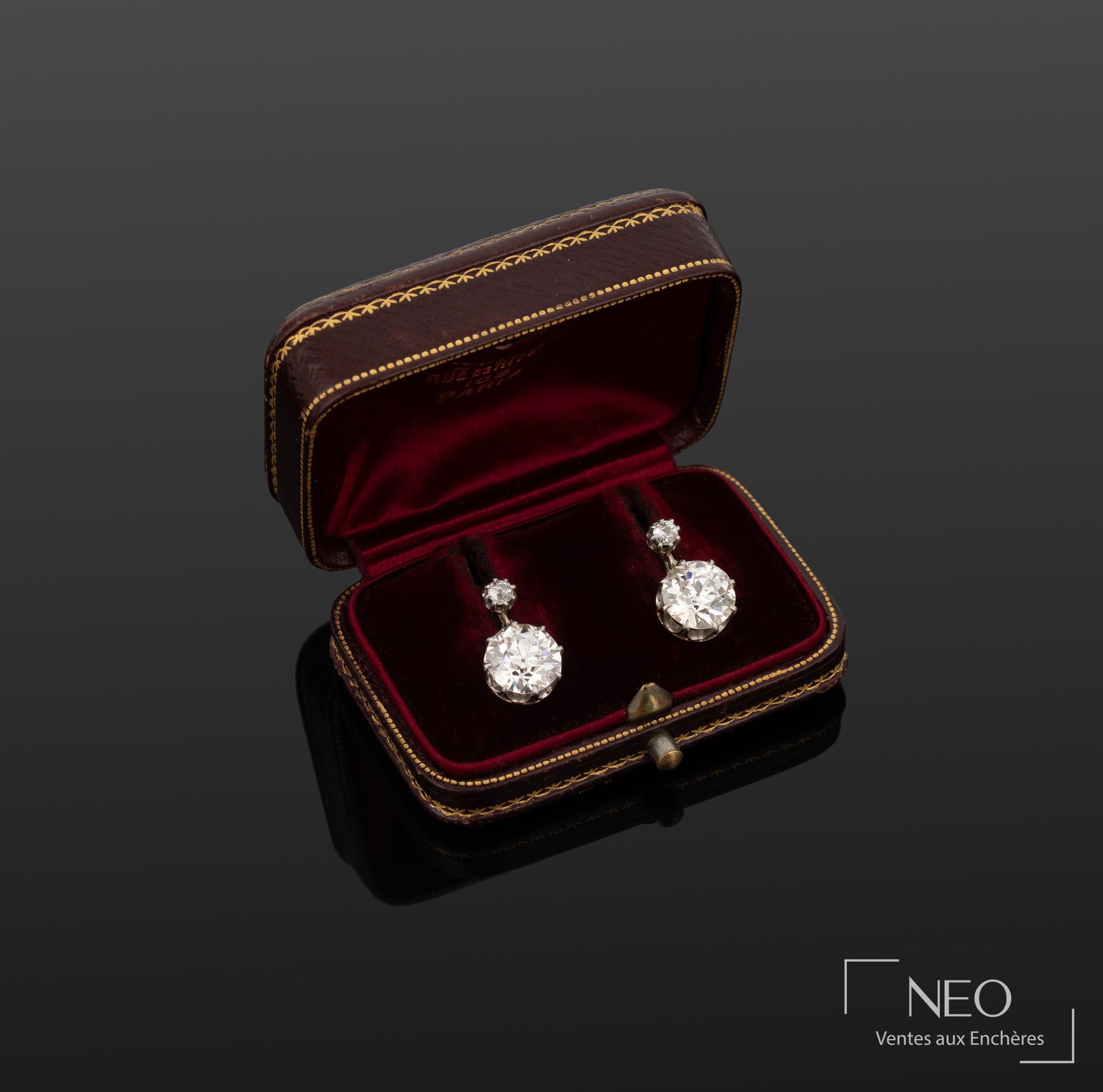 Paire de pendants d’oreilles en or gris avec diamants présentée dans son écrin