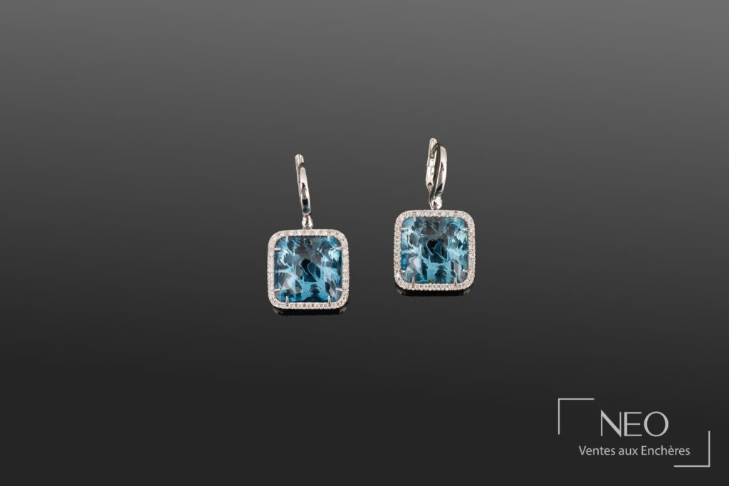 Paire de pendants d'oreilles ornés de topazes london et diamants sur fond gris