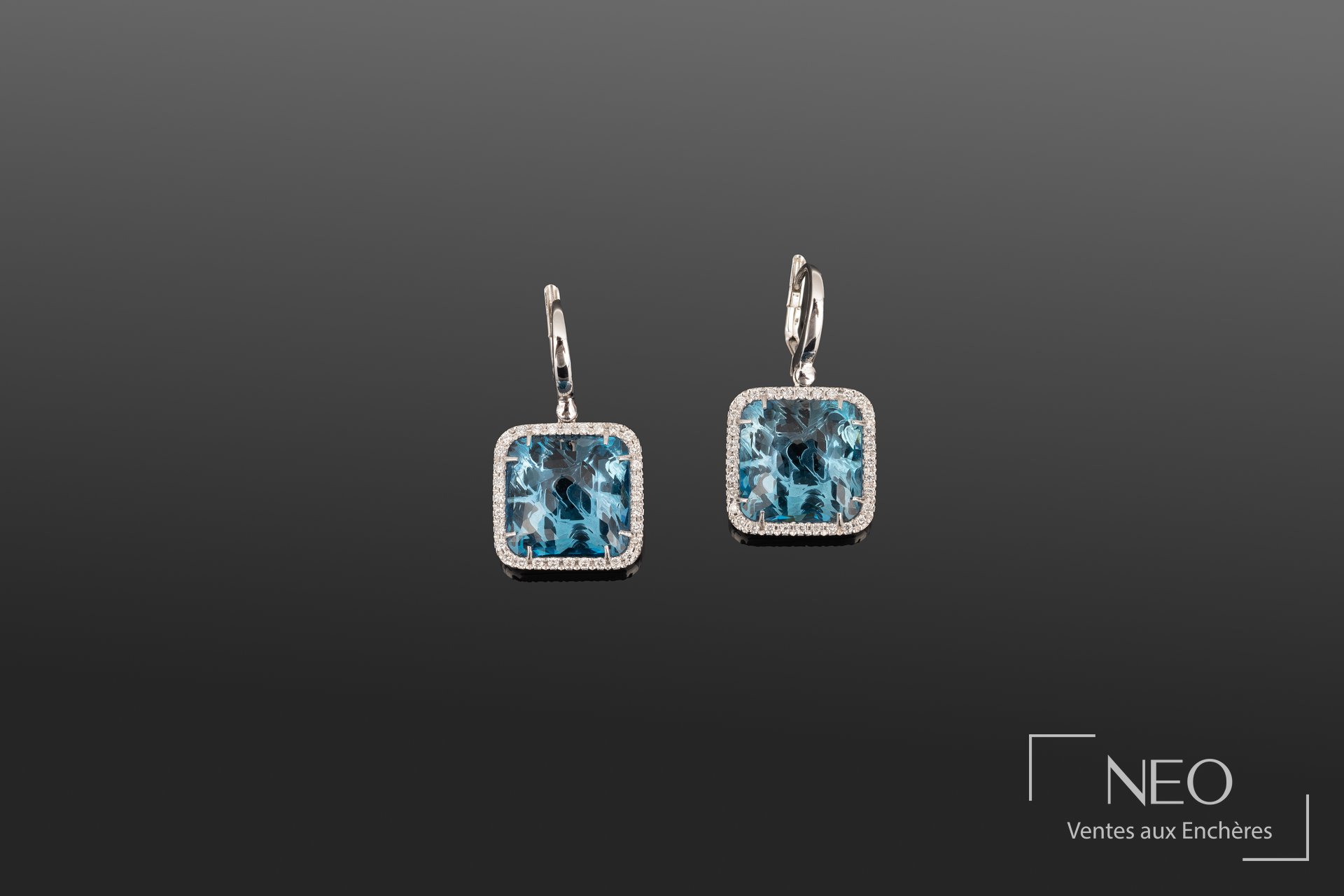 Paire de pendants d'oreilles ornés de topazes london et diamants sur fond gris